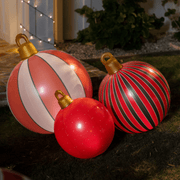 Three inflatable Christmas ornaments in red, white, and black stripes on grass.
